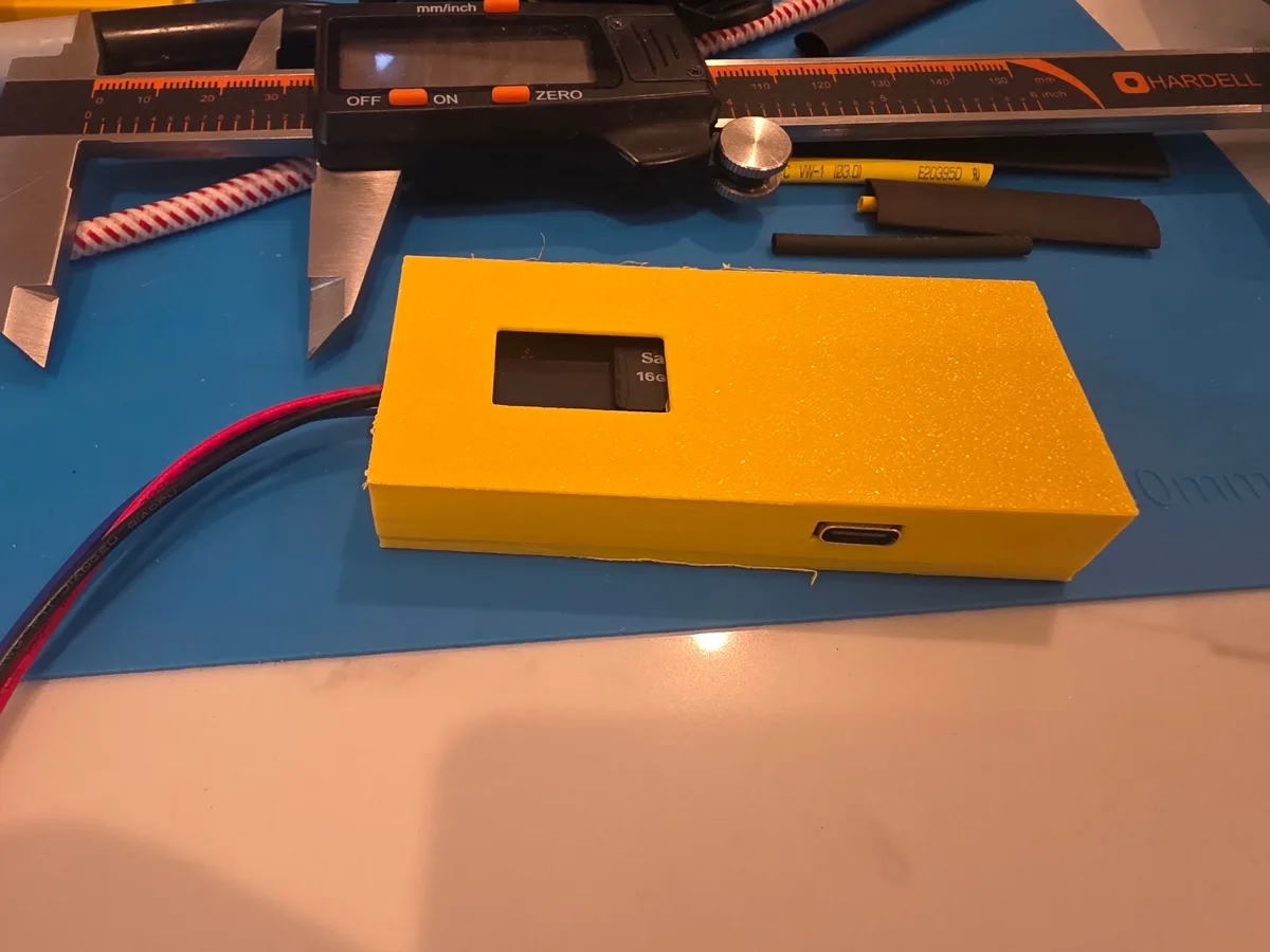 3D-printed Bee Reviver prototype with a window showing a microSD card in its slot and a USB-C port on the side